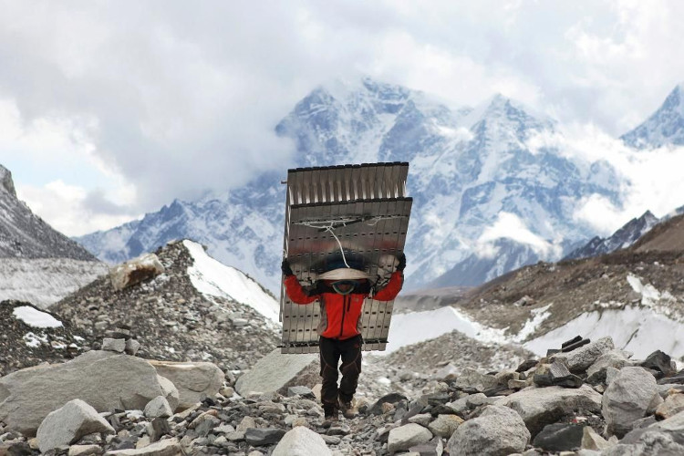 Một người Sherpa vác thang cho người đi chinh phục đỉnh Everest.
